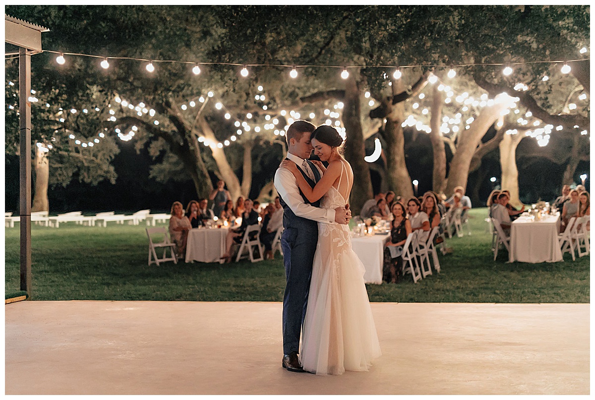bride and groom first dance outside under the lights