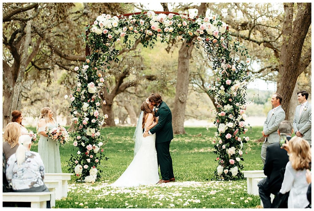 wedding ceremony under floral arch in Boerne, TX