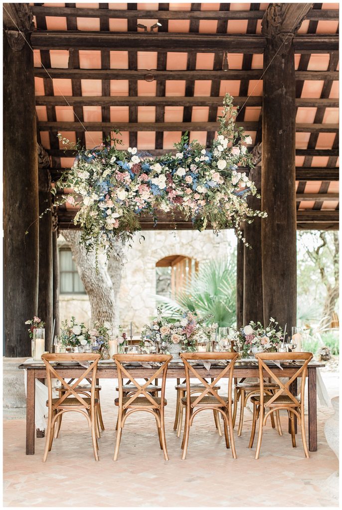 sweetheart table with overhead floral arrangement in Camp Lucy