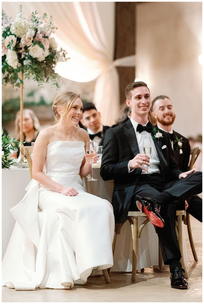 bride and groom sit during toasts
